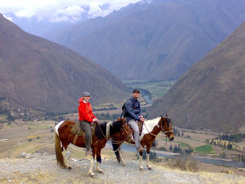 Dos viajeros a caballo en un mirador sobre el Valle Sagrado
