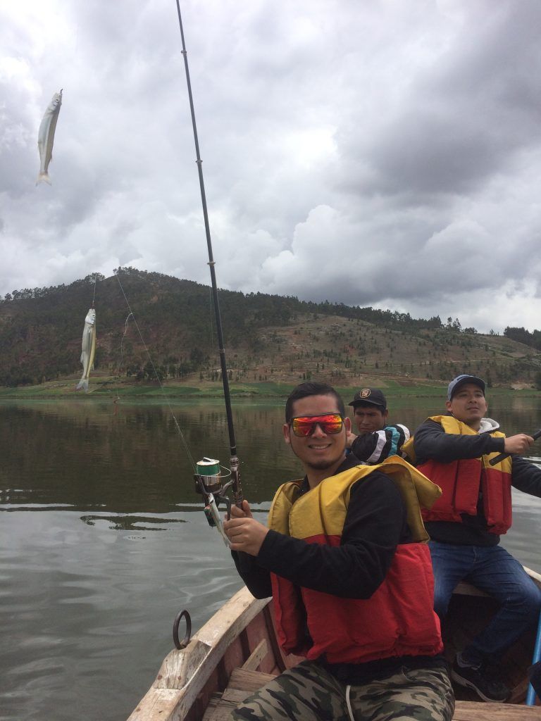 Viajero pescando desde un bote en una laguna andina