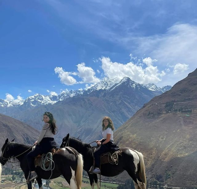 Dos viajeras a caballo frente a los nevados del Valle Sagrado