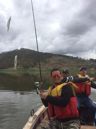 Travellers in life jackets fishing from the boat